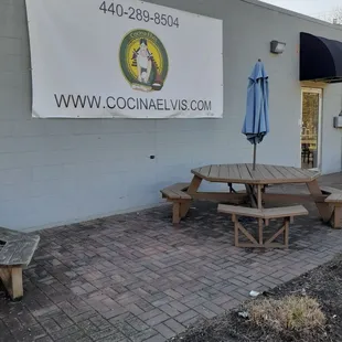a picnic table and umbrella in front of a building