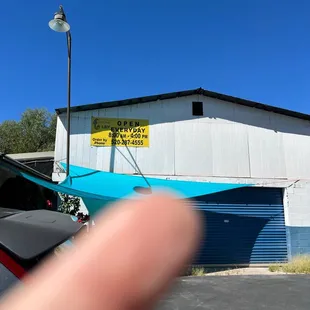 a person's finger in front of a building