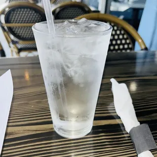 a glass of ice water with a straw