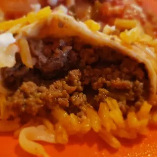 The rice is pulled away from the burrito and the hardened cheese is completely stuck to it