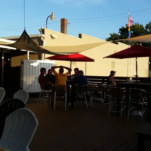 people sitting at tables with umbrellas