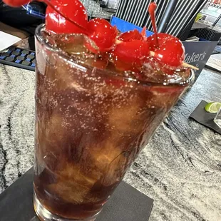 a drink with cherries in a tall glass