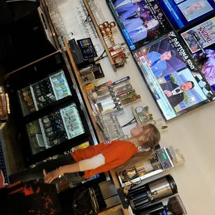 a woman standing in front of televisions