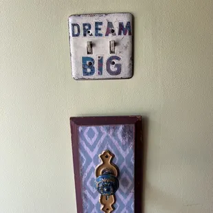 a coffee maker and a ceramic plaque on a wall