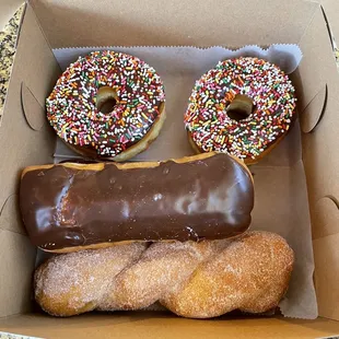 a box of doughnuts with chocolate frosting and sprinkles