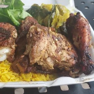 Jerk Chicken, yellow rice, plantains, cabbage, and green salad.