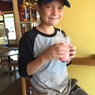 a young boy holding a drink