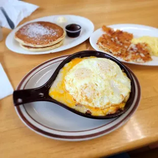 Country Skillet with side of pancakes   Eggs and potatoes