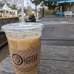 a cup of iced coffee on a picnic table