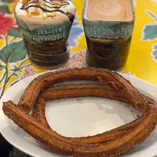 a plate of churros and a cup of coffee