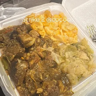 Supposedly a LARGE GOAT .. Mac n cheese .. cabbage ! LITTLE GOAT ON TOP .. full of rice on the bottom