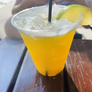 a drink in a plastic cup on a wooden table