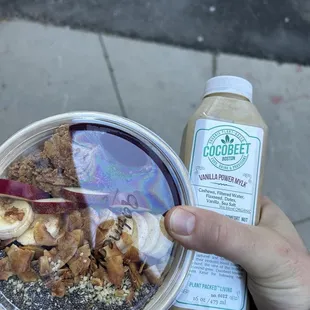 a person holding a cup of ice cream and a banana