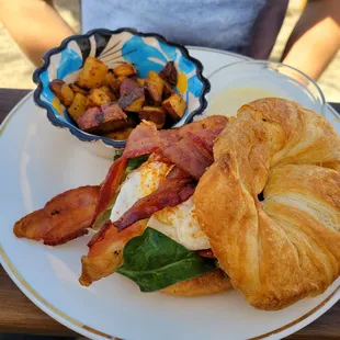 a croissant sandwich with bacon and eggs