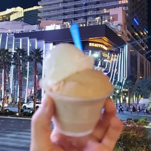 a hand holding a cup of ice cream