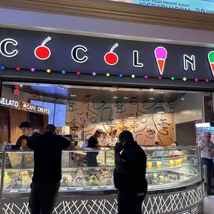 a group of people standing in front of a ice cream shop