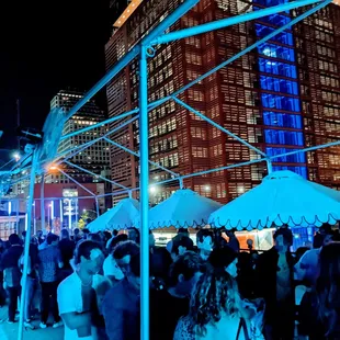 a crowd of people standing under umbrellas