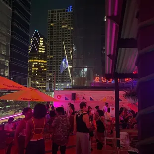 a crowd of people at a rooftop bar