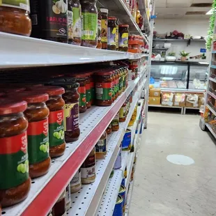 a grocery store aisle filled with jars of condiments