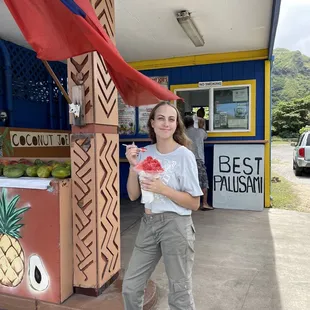a woman standing in front of a fruit stand
