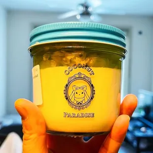 a hand holding a jar of honey