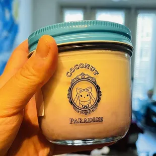 a hand holding a jar of coconut paradise
