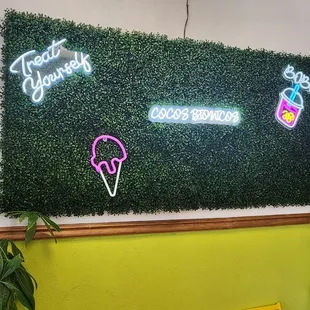 a green wall with neon signs