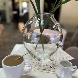 a vase of flowers and a cup of coffee