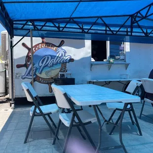 tables and chairs under a blue shade