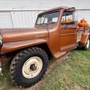 an old truck with pumpkins in the bed