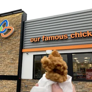 a person holding a stuffed animal in front of a store