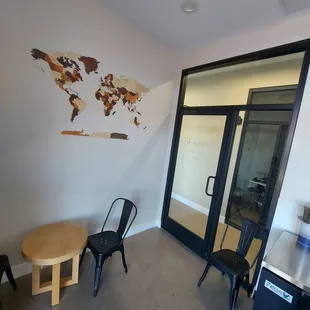 a table and chairs in a room with a map on the wall