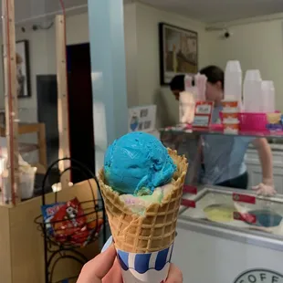 a person holding a cone of ice cream