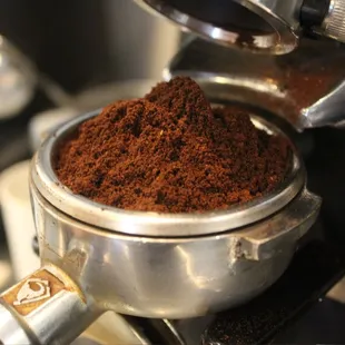 a coffee grinder with a cup of coffee