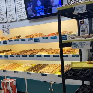 a man standing in front of a display of donuts