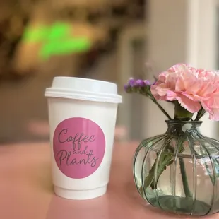 a cup of coffee and a vase of flowers