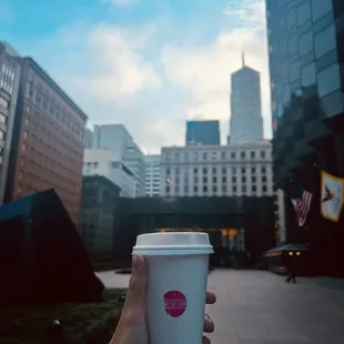a hand holding a coffee cup