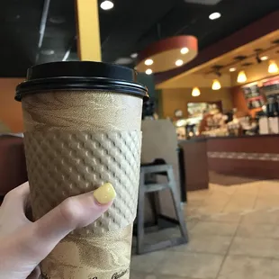a hand holding a coffee cup
