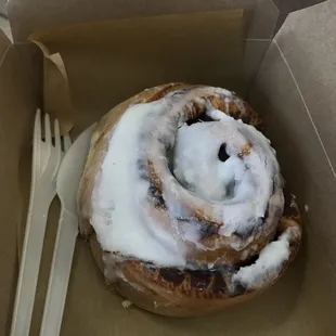 a cinnamon roll with icing and a fork