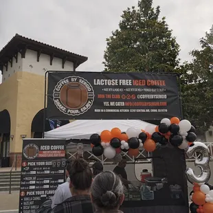 a crowd of people standing in front of a coffee truck