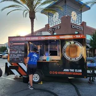 a woman standing in front of a food truck