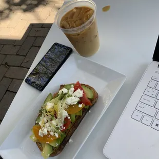 a sandwich with avocado, tomatoes, and cheese