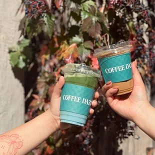two people holding cups of coffee