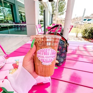 a hand holding a cup of coffee
