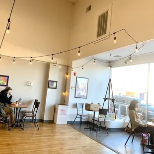 two people sitting at tables in a coffee shop