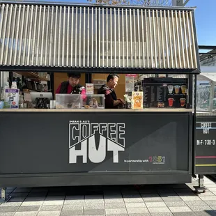 a man standing in front of a coffee kiosk