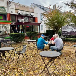 two men sitting at a table outside