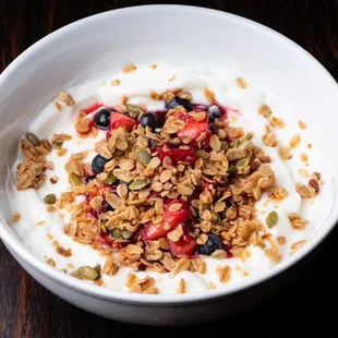a bowl of yogurt with granola and berries