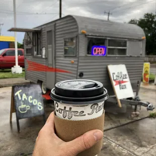 a hand holding a coffee cup