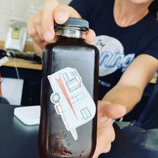 a woman holding a bottle of coffee